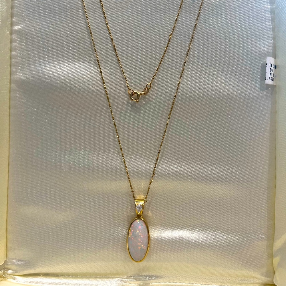 Fashion pendant with oval cut Opal and pear shaped accent diamond.